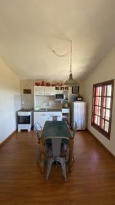 eine Küche mit einem Tisch und Stühlen im Zimmer in der Unterkunft Cabaña Sol y Luna in Villa Serrana