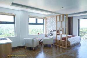 1 dormitorio con 1 cama, mesa y sillas en Khánh Phương Luxury en Châu Làng Chánh