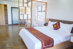 a bedroom with a large bed with white sheets at Khánh Phương Luxury in Châu Làng Chánh