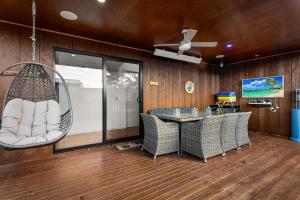 a room with a table and chairs and a ceiling fan at Castlebay in Wimbledon Heights