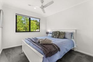 una camera bianca con un letto e una finestra di Castlebay a Wimbledon Heights