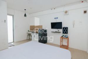 a white room with a bed and a tv at RedLiving Apartemen Bassura City - Aokla Property Tower Dahlia in Jakarta