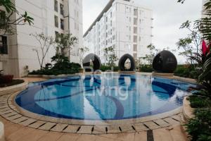 a large swimming pool in the middle of a building at RedLiving Apartemen Bassura City - Aokla Property Tower Dahlia in Jakarta