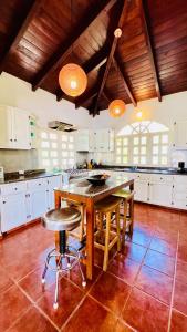 cocina grande con mesa de madera y sillas en PALM HOUSE - LUXURY VILLA - SAMANÁ - Ocean Front en Sánchez