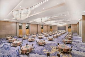 un gran salón de banquetes con mesas y sillas en Vasa Hotel Surabaya, en Surabaya