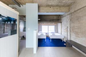 een ziekenhuiskamer met witte bedden en blauw tapijt bij RE SORT in Sasebo