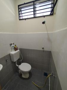 a bathroom with a toilet and a sink and a window at Homestay CikguRose UMK in Bachok