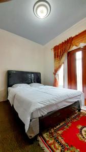 a large bed in a bedroom with a window at Homestay Merpati Dieng Syariah RedPartner in Diyeng