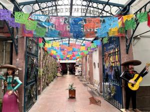 an alleyway with colorful flags and guitars in a building at Apartment in the touristic heart of Mexico City in Mexico City