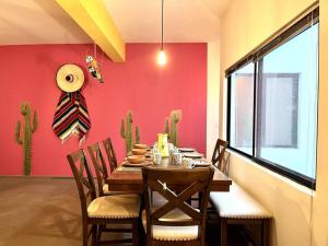 a dining room with a table and chairs and a red wall at Apartment in the touristic heart of Mexico City in Mexico City