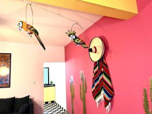 a room with a pink wall with two birds and a tie at Apartment in the touristic heart of Mexico City in Mexico City