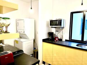a kitchen with a counter and a refrigerator and a microwave at Apartment in the touristic heart of Mexico City in Mexico City