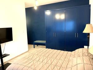 a bedroom with a bed and a blue wall at Apartment in the touristic heart of Mexico City in Mexico City
