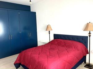 a bedroom with a red bed and blue cabinets at Apartment in the touristic heart of Mexico City in Mexico City