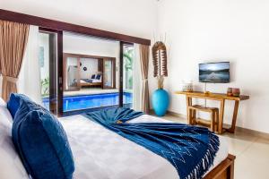 a bedroom with a bed and a view of a pool at Villa Joyosa in Seminyak +34 photos