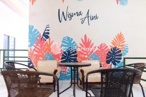 Kedaton的住宿－Wisma Aini Syariah Mitra RedDoorz，用餐室配有椅子和带壁画的墙壁