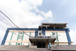 Kedaton的住宿－Wisma Aini Syariah Mitra RedDoorz，前面有标志的建筑
