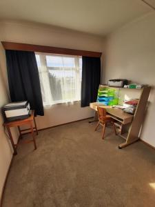 an empty room with a desk and a window at Mary's Place in Opotiki