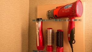 a shelf with a red blow dryer and other utensils at Sakura Sky Hotel in Tokyo