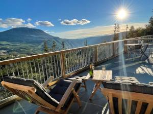 a balcony with a table and chairs and a mountain at Gaustatoppen Lodge - Mountain View - Gaustablikk in Rjukan