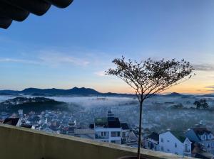 una vista de una ciudad con niebla a lo lejos en Century House, en Da Lat
