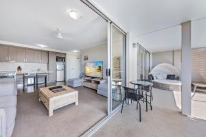 a living room with a couch and a table at Candlelight - Airlie Beach in Airlie Beach