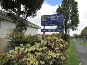a sign for the retention court motel next to flowers at Fenton Court Motel in Rotorua