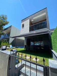 ein modernes Haus mit einem Zaun davor in der Unterkunft Özel havuzlu lüks villa in Kusadası