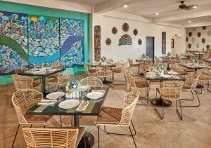 un comedor con mesas y sillas y un mural en Tag Resort en Corón