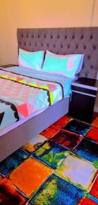 een slaapkamer met een bed en een kleurrijke vloer bij Pmb Guest House in Pietermaritzburg