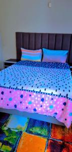 a bed with polka dot sheets and pillows on it at Pmb Guest House in Pietermaritzburg