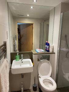 a bathroom with a toilet and a sink at King Dems Home in Dagenham