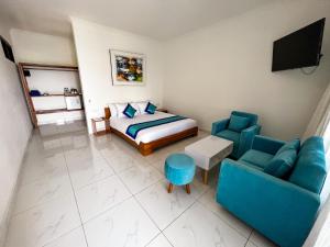 スンギギにあるBeach Club Lombok by Bale Solahのベッド、ソファ、テレビのある寝室