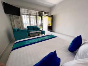 スンギギにあるBeach Club Lombok by Bale Solahのベッドルーム(大型ベッド1台、青い椅子付) +40枚の写真