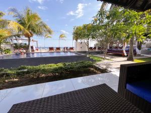 スンギギにあるBeach Club Lombok by Bale Solahのヤシの木と海の景色を望むスイミングプールを望めます。