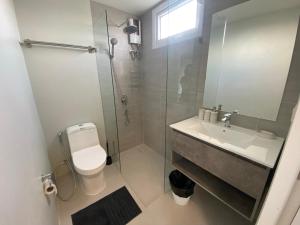 a bathroom with a shower and a toilet and a sink at Mantra Beach Condominium Suite 2 - Mae Phim in Ban Tha Fat