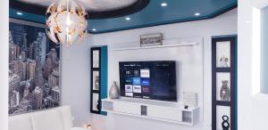 ein Wohnzimmer mit einem TV und einem Kronleuchter in der Unterkunft M/H house (#1) cozy and beautiful house near the airport and the beach in Carolina