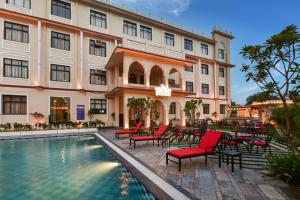 a hotel with a pool and chairs and a building at Ranbanka Heritage Resort 1 km from Bhilwara Railway Station in Bhilwara