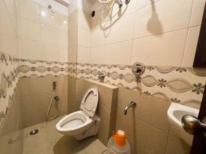 a bathroom with a toilet and a sink at Hotel InTourist by Agira Hotel in Bangalore