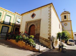 a building with a door and a clock tower at Casa cueva con encanto in Terque
