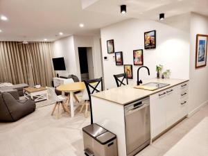 a kitchen and living room with a couch and a table at Maroochy City Lights@Thecosmopolitan Unit 20802 in Maroochydore