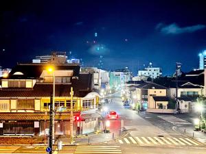 uma rua da cidade à noite com carros na estrada em 外宮前別邸　星凪庵 em Ise