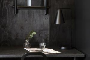 a table with a lamp and a vase on it at Tykkimäki Resort in Kouvola