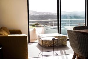 een woonkamer met stoelen en uitzicht op een balkon bij Résidence Le Lonca PORTICCIO in Porticcio