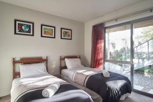 two beds in a room with a window at Stunning Bob Lee Place in Wanaka