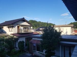 balcone con vista su una casa. di Guest House Tatara a Yasugi