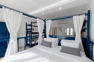 Schlafzimmer mit blauen Etagenbetten und weißen Kissen in der Unterkunft Ammos stegna in Archangelos