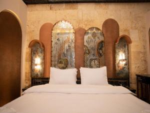 a bedroom with a large white bed with two pillows at Bayazhan Hotel ve Restaurant in Gaziantep