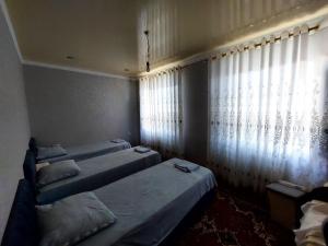 a room with three beds and a window at Green house in Nukus