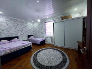 a bedroom with two beds and a rug at Green house in Nukus